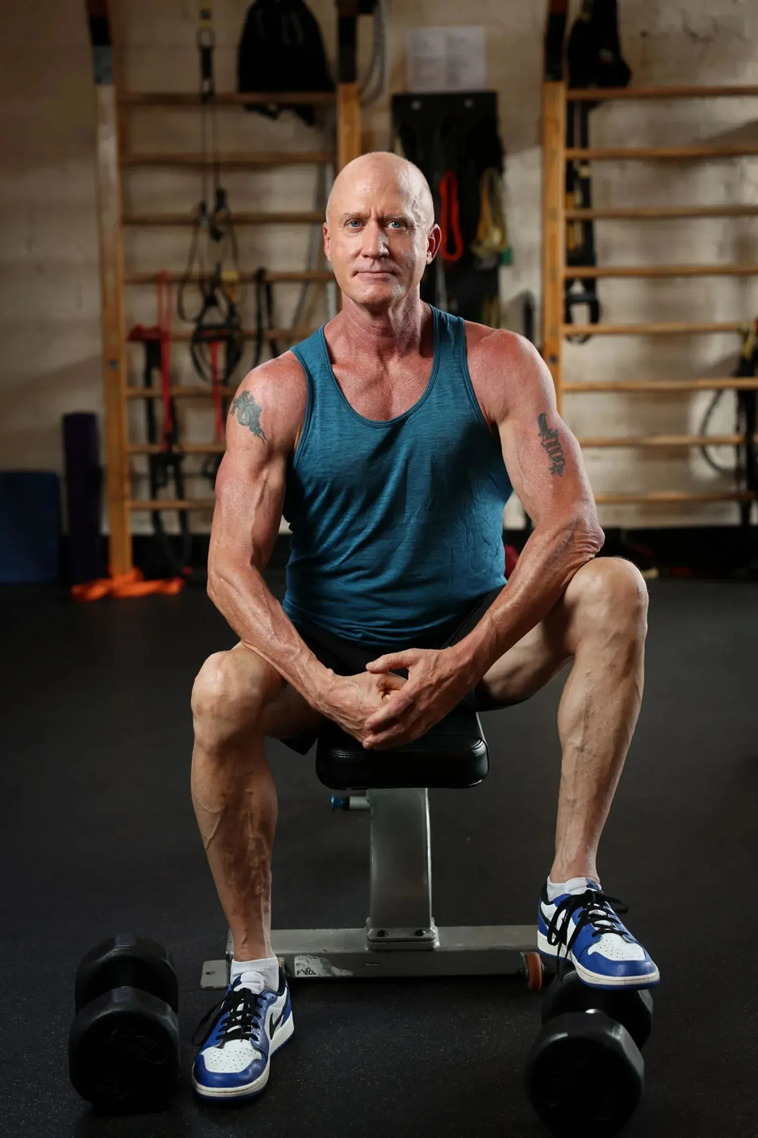 Man seated in a gym between training sets