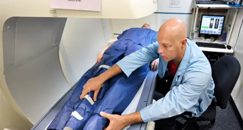 Technician positioning a patient for a DEXA body composition scan